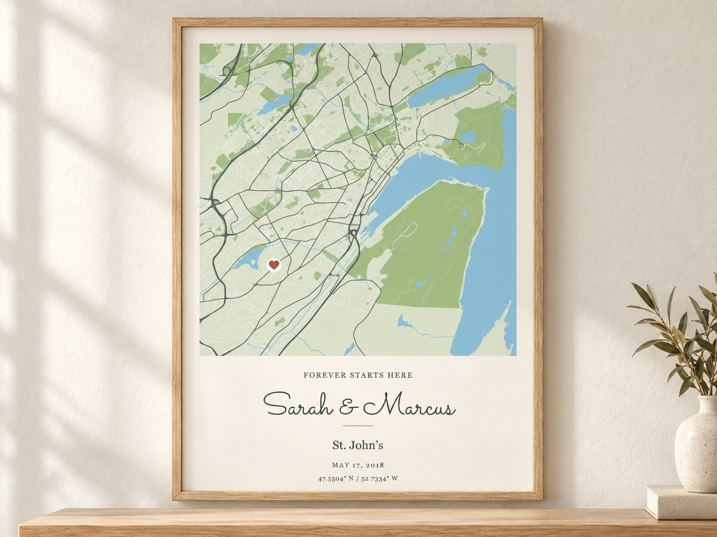 Natural green personalized map print in an oak frame on a sunlit wall